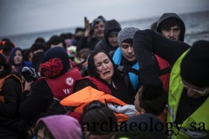 An Afghan woman holding her son reacts as they arrive with other refugees and migrants from the Turkish coast to Mytilene, Lesbos island, Greece, on Wednesday, Feb. 24, 2016. The International Organization for Migration said more than 102,500 people had crossed into Greece since Jan. 1 and another 7,500 had streamed into Italy  numbers that weren't reached last year until June. (AP Photo/Manu Brabo)