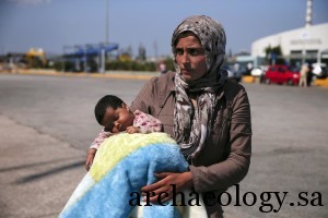 A Syrian refugee holds her baby following their arrival onboard the Eleftherios Venizelos passenger ship at the port of Piraeus, near Athens, Greece September 8, 2015. The ship crammed with thousands of mostly Syrian refugees docked in Greece's main port of Piraeus on Tuesday, after the government said it was stepping up efforts to ease pressure on an eastern island being overwhelmed by new arrivals.REUTERS/Alkis Konstantinidis - RTX1RM2R