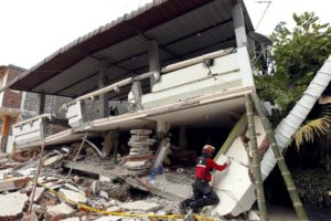 A fireman searches through debris after an earthquake struck off Ecuador's Pacific coast, at Tarqui neighborhood in Manta April 17, 2016. REUTERS/Guillermo Granja
