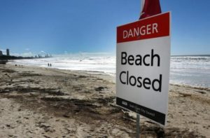 A sign is displayed on a beach that was closed due to dangerous surf conditions at Burleigh Heads on Queensland's Gold Coast, Australia, June 5, 2016.   AAP/Dan Paled/via REUTERS